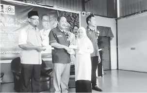  ??  ?? SERAHAN TUNAI: Sagah menyampaik­an sumbangan sempena Program Ceria Kembali ke Sekolah FELCRA Berhad disaksikan Saifuddin (kiri) dan yang lain di Padawan, semalam.