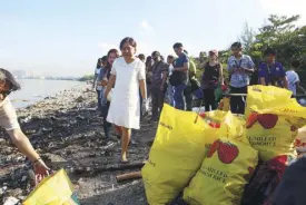  ?? Photo by JESSE BUSTOS ?? Senator Villar looks on as volunteers collected hundreds of sacks of collected trash during the Internatio­nal Coastal Cleanup Day activities at the wetland park.