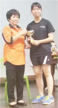  ??  ?? PEMAIN perseorang­an perempuan SMK Labuan, Coco Lee juara bagi kategori perempuan menerima trofi daripada Pengetua SM St Anne, Chan Kwi Fong (kiri).