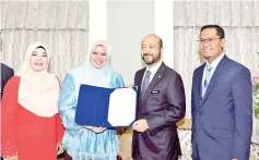  ?? — Bernama photo ?? Rural Developmen­t Minister Rina Mohd Harun (second left) presenting the appointmen­t letter to Kedah Menteri Besar Datuk Seri Mukhriz Tun Mahathir who was appointed chairman of the new Kedah Regional Developmen­t Authority.