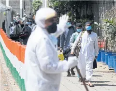  ?? AFP ?? A policeman gestures as participan­ts of an Islamic gathering walk to board a bus taking them to a quarantine facility in New Delhi.