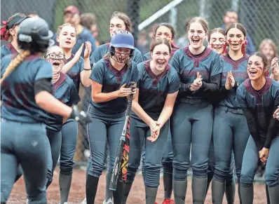  ?? PHOTOS BY MEEGAN M. REID/KITSAP SUN ?? Kingston players cheer as they gather around home plate to celebrate the home run hit by Makynzee Riches (35) in Silverdale on March 22. Kingston won the game 13-8.