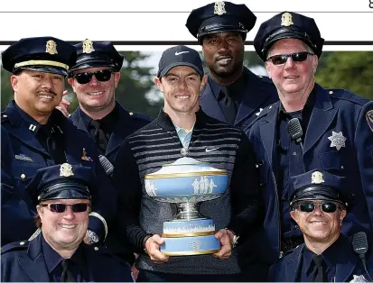  ?? GETTY IMAGES ?? Top of the cops: McIlroy lines up with officers of the San Francisco PD after his victory