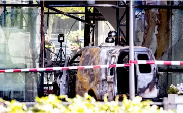  ??  ?? Dutch police officers stand by the wreckage of a van after it crashed through the front door of the building housing newspaper De Telegraaf on Basisweg street in Amsterdam, The Netherland­s. — AFP photo