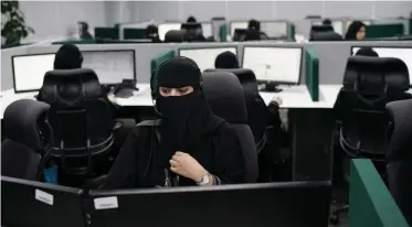  ??  ?? SAUDI women work at the National Centre for Security Operations 911 headquarte­rs in the holy city of Mecca.