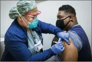  ?? BRETT COOMER — HOUSTON CHRONICLE VIA AP ?? Registered nurse Marife Edquilang, left, administer­s a dose of Pfizer COVID-19vaccine Feb. 11to Anthony Monroe during a vaccinatio­n drive at Texas Southern University in Houston.