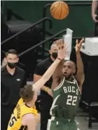  ?? AP ?? The Bucks’ Khris Middleton sinks the winning shot over the Heat’s Duncan Robinson with 0.5 seconds left in overtime Saturday.