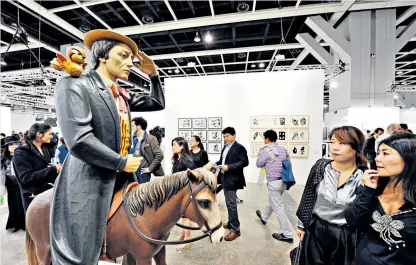  ??  ?? In their sights: potential buyers look at Buster Keaton by Jeff Koons on the ABHK preview day