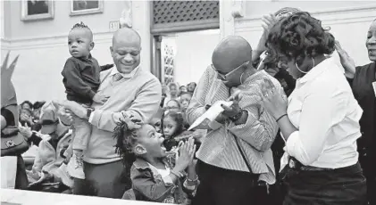  ?? KIM HAIRSTON/BALTIMORE SUN PHOTOS ?? Jerry Haskins, Reistersto­wn, watches as his daughter, Sage Harris, 4, celebrates her adoption with her mother, Dawnyell Harris, and sister, Kristyana Harris, 14. They are among the families taking part in an adoption ceremony on National Adoption Day.