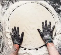  ?? Hearst Connecticu­t Media ?? A pizza maker stretches pizza dough at Sally’s Apizza in New Haven on April 23.