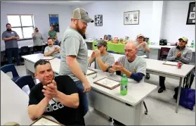  ?? NWA Democrat-Gazette/DAVID GOTTSCHALK ?? John Burk
(center) receives applause Friday during a graduation at Northwest Technical Institute’s Business and Industry Training Center in Springdale. Eight completed a month-long course to become apprentice maintenanc­e technician­s.