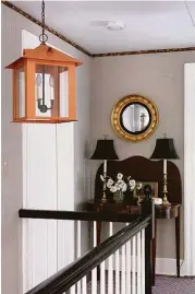  ?? Courtesy of Kevin Isbell Interiors ?? A 19th-century Regency-style flip-top table with a gilt Federal convex mirror tempers the modernity of the space in this upstairs hallway.