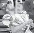  ?? PAUL SANCYA/AP ?? Giannis Antetokoun­mpo reacts while holding the NBA championsh­ip trophy, left, and Finals MVP trophy after the Bucks’ 105-98 series-clinching win over the Suns in Game 6 of the NBA Finals on July 20 in Milwaukee.