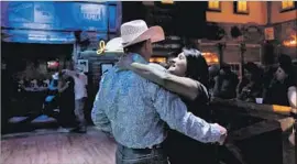  ??  ?? “HOW FUNNY is it that I’m an Indian and he’s a cowboy?” said Dee Dee Jozwiak, a full-blooded Comanche, dancing with Jaylon Jacobsen at a Houston bar.