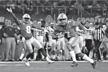  ?? Associated Press ?? Ohio State safety Damon Webb (7) runs an intercepti­on in for a touchdown in front of cornerback Kendall Sheffield (8) during the first half of the Cotton Bowl NCAA college football game Friday against Southern California in Arlington, Texas.