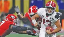  ?? STAFF PHOTO BY C.B. SCHMELTER ?? Alabama quarterbac­k Tua Tagovailoa evades Georgia linebacker­s Davin Bellamy, left, and D’Andre Walker as he scrambles for a 9-yard gain during the championsh­ip game of the 2017 college football season. The matchup at Atlanta’s Mercedes Benz-Stadium kicked off on Monday, Jan. 8, 2018, but it didn’t finish until after midnight.