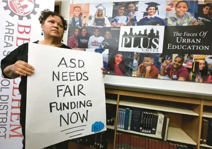  ?? RICK KINTZEL/THE MORNING CALL ?? Linda Borrero of Allentown, who has a daughter who attends Building 21 high school, holds a sign asking for fair funding March 28 during a news conference at Northeast Middle School in Bethlehem.