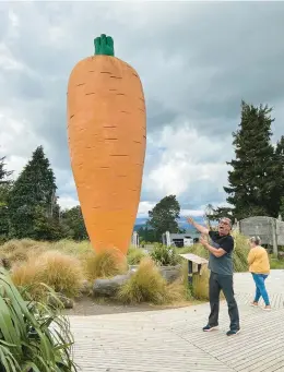  ?? ?? Mark Hockley of Great Journeys shows off a massive carrot sculpture, the centerpiec­e of Ohakune Carrot Adventure Park in Okahune.