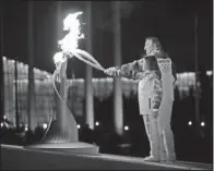  ?? The Associated Press ?? FIRED UP: Irina Rodnina and Vladislav Tretiak light the Olympic cauldron during the Winter Olympics opening ceremony Friday night in Sochi, Russia. Rodnina won figure skating gold medals for the Soviet Union in 1972, 1976 and 1980, and Tretiak played...