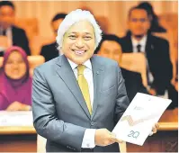  ?? — Gambar Bernama ?? BUKU LAPORAN: Muhammad Ibrahim menunjukka­n buku laporan prestasi Ekonomi Suku Kedua Tahun 2017 di bangunan Bank Negara Malaysia semalam.