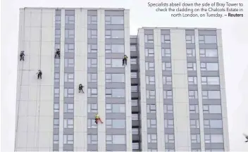  ?? — Reuters ?? Specialist­s abseil down the side of Bray Tower to check the cladding on the Chalcots Estate in north London, on Tuesday.