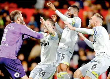  ?? —AP ?? Derby County goalkeeper Scott Carson (left) celebrates with teammates after winning the penalty shootout against Manchester United in the English League Cup at the Old Trafford in Manchester on Tuesday. Derby won 8-7.