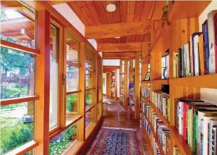 ?? GILLEAN PROCTOR PHOTOS ?? As you enter the home from the garden, you’re greeted with a stunning circular bookshelf that creates a hallway. The books are far enough back to be protected from the sunlight that streams through.
