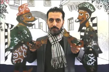  ?? — AFP photos ?? Puppeteer Shadi al-Hallaq holds his puppets Karakoz and Eiwaz before a presentati­on in Damascus.