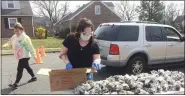  ?? MEDIANEWS GROUP FILE PHOTO ?? When Gov. Tom Wolk closed schools in March, the Pottstown School District immediatel­y began distributi­ng free food at its four elementary schools to ensure students fed at school continued to be fed. In this photo taken in March, resident Holly Russell, wearing gloves and a mask, gets food at Franklin Elementary School.