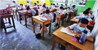  ??  ?? Tham’s pupils use the smartphone­s provided by him to do their schoolwork.