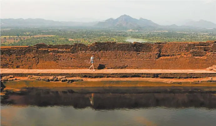  ??  ?? A tourist explores the summit of Sigiriya,
Sri Lanka.