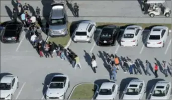  ?? ASSOCIATED PRESS ?? In this Feb. 14 photo, students are evacuated by police from Marjory Stoneman Douglas High School in Parkland, Fla., after a shooter opened fire on the campus, killing 17 people.