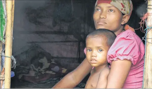  ?? AP PHOTO ?? Rosmaida Bibi, who suffers from severe malnutriti­on, sits on her mother Hamida Begum’s lap at their makeshift shelter at the Dar Paing camp, north of Sittwe, Rakhine State, Myanmar.