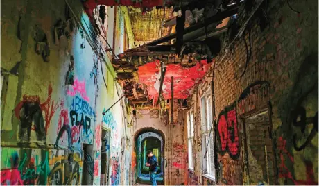  ??  ?? A journalist takes notes as he explores an abandoned building in Berlin.