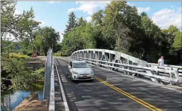  ?? TANIA BARRICKLO — DAILY FREEMAN FILE ?? A car crosses the rebuilt Wynkoop Road bridge over the Esopus Creek in Hurley in August 2014. The bridge, owned by Ulster County, replaced a deteriorat­ing span that was 80 years old.