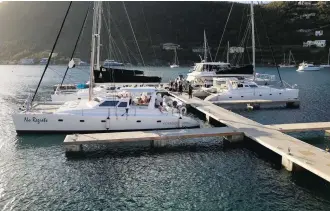  ??  ?? Guests board three of Voyage Charters’ catamarans at the Harbour Market docks in Soper’s Hole, Tortola.