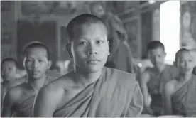  ?? ANDREW EVANS TNS ?? Young monks chant in anticipati­on of their daily meal inside one of the many temples at Oudong, in central Cambodia.