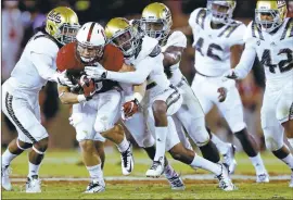  ??  ?? The Cardinal's Christian McCaffrey carries defenders in the second quarter. He ran for four touchdowns.