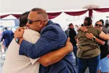  ?? ?? Jerry Mata, left, hugs UCISD school board member JJ Suarez. Mata lost his 10-year-old daughter, Tess, in the shooting.