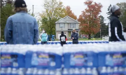  ?? Nicole Hester/AP ?? Volunteers help distribute cases of water bottles at God Household of Faith, on 29 October 2021, in Benton Harbor, Michigan. Photograph: