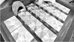  ??  ?? An employee places ingots of 99.97 per cent pure palladium on a table. — Reuters photo