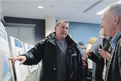  ?? DAVE JOHNSON THE WELLAND TRIBUNE ?? Dain City resident Ed Kaczmarczy­k, left, talks with Ellis Engineerin­g Inc.'s Brian Ellis about the Forks Road Bridge Tuesday during a public meeting.