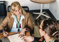  ?? JAMIE KELTER DAVIS / THE NEW YORK TIMES ?? Barbara Martinez, a financial counselor at nonprofit Heartland Alliance, works with a client in Chicago, on Dec. 15. Martinez said many of her clients use cash advances to cover pay-later loans and create a cycle of debt.