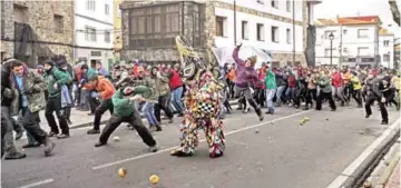  ??  ?? People throw turnips at the Jarramplas as he makes his way through the streets beating his drum during the Jarramplas festival in the tiny southweste­rn Spanish town of Piornal, Spain. — AP
