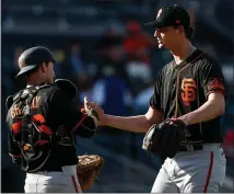  ?? RANDY VAZQUEZ — STAFF PHOTOGRAPH­ER ?? Giants pitcher Sean Hjelle, right, shakes hands with catcher Rob Brantly after closing out Sunday’s Cactus League game against the A’s at Hohokam Stadium in Mesa, Ariz.