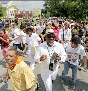  ?? AP/GERALD HERBERT ?? A second-line parade Saturday to commemorat­e the 10th anniversar­y of Hurricane Katrina moves past homes built by actor Brad Pitt’s Make It Right Foundation in the Lower Ninth Ward in New Orleans.