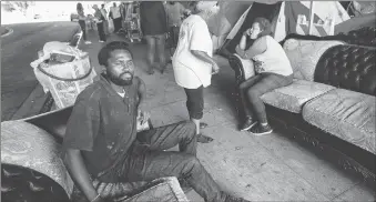  ?? Los Angeles Times/tns ?? Dennis Karimi, 30, sits on a couch that also serves as his bed at a homeless encampment located under the 118 fwy in Pacoima in July. Caltrans wants to oust everyone from this location, but it has been delayed due to a legal challenge.