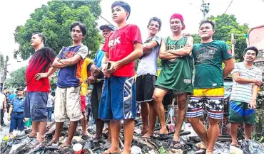  ??  ?? Moving on This family forgets the tragic fire in their abode by stepping on what remained of their house in Malabon.