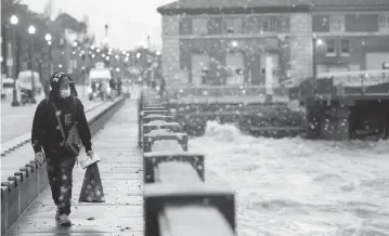  ?? GODOFREDO A. VÁSQUEZ AP ?? A person walks along The Embarcader­o in San Francisco on Wednesday as the second major winter storm of the week moved into California, walloping the parched northern part of the state with more rain and snow.