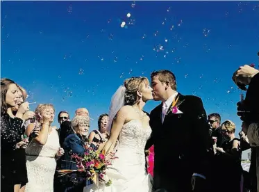  ??  ?? Guests blow bubbles at the bride and groom following their nuptials at RedTail Landing Golf Course, south of Edmonton.